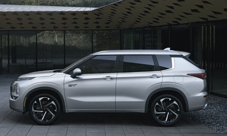 2024 Mitsubishi Outlander PHEV parked by a modern home