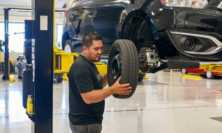 Mitsubishi technician replacing tire